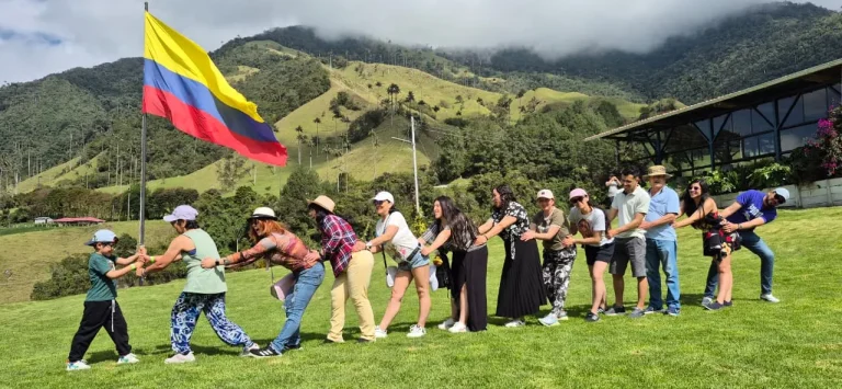 Grupo de viajeros de Dominick Travel con la bandera de Colombia en el Valle del Cócora